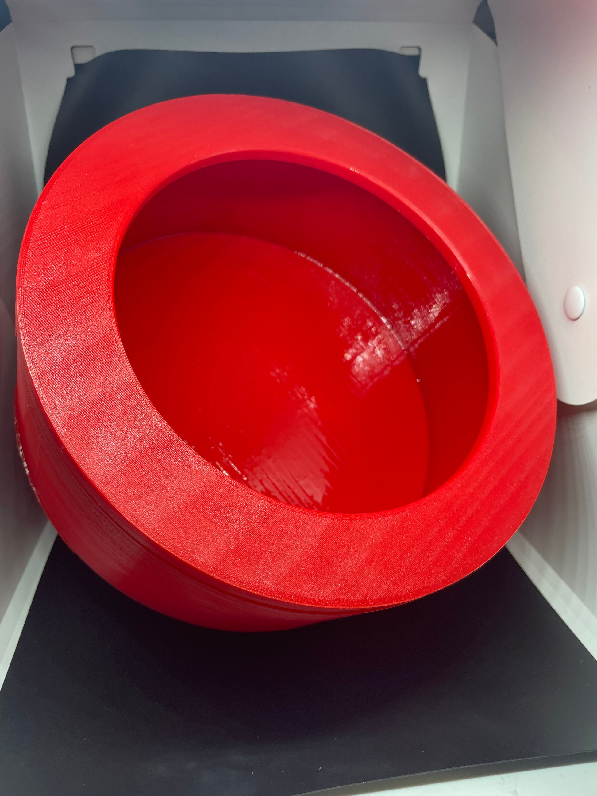 Red 3D printed bowl, visible layer lines.