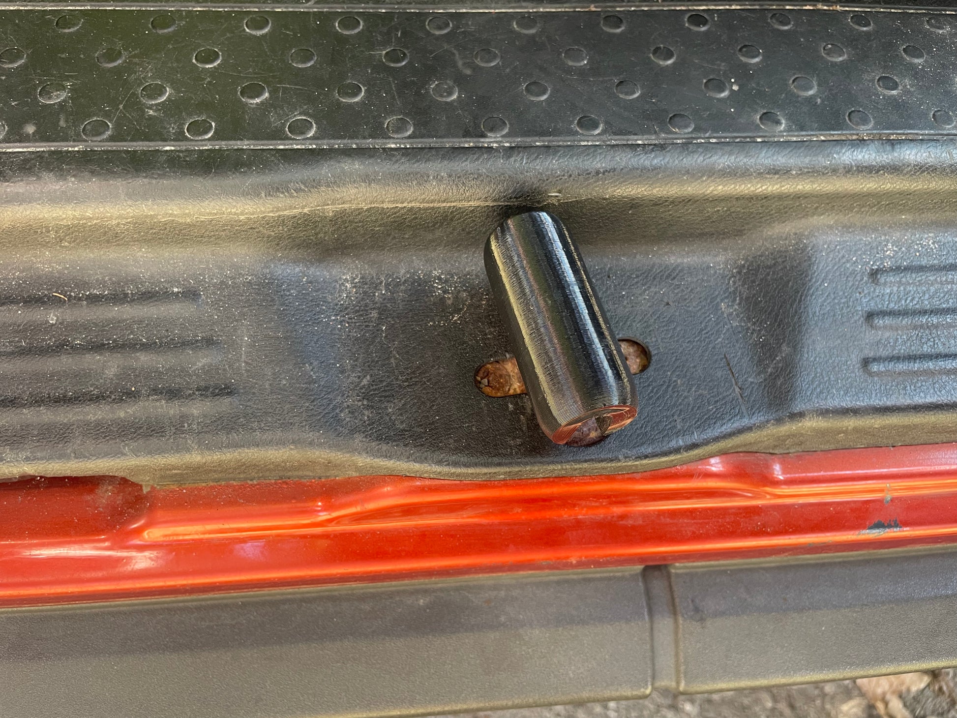 Close-up of a black shift knob on a vehicle's floor.