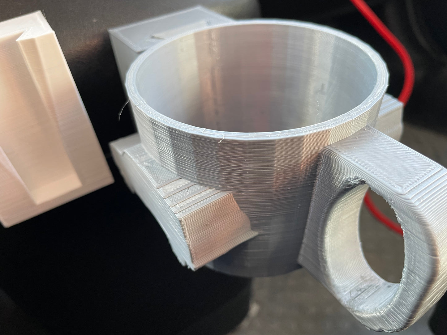 3D-printed silver cup holder with handle.