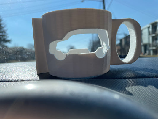 3D printed white mug with a Jeep cutout on a car dashboard.