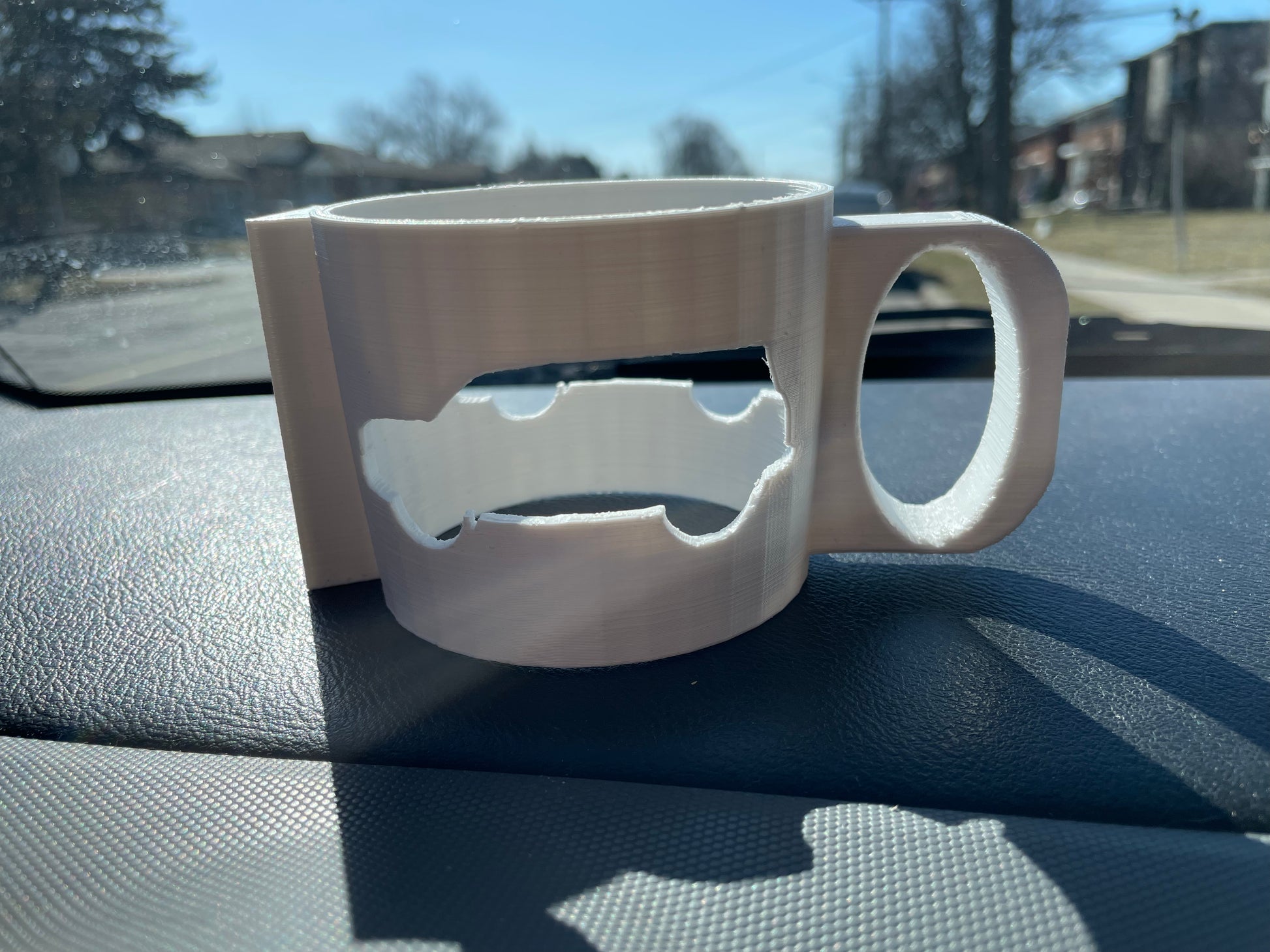 White 3D printed mug with car cut out design.