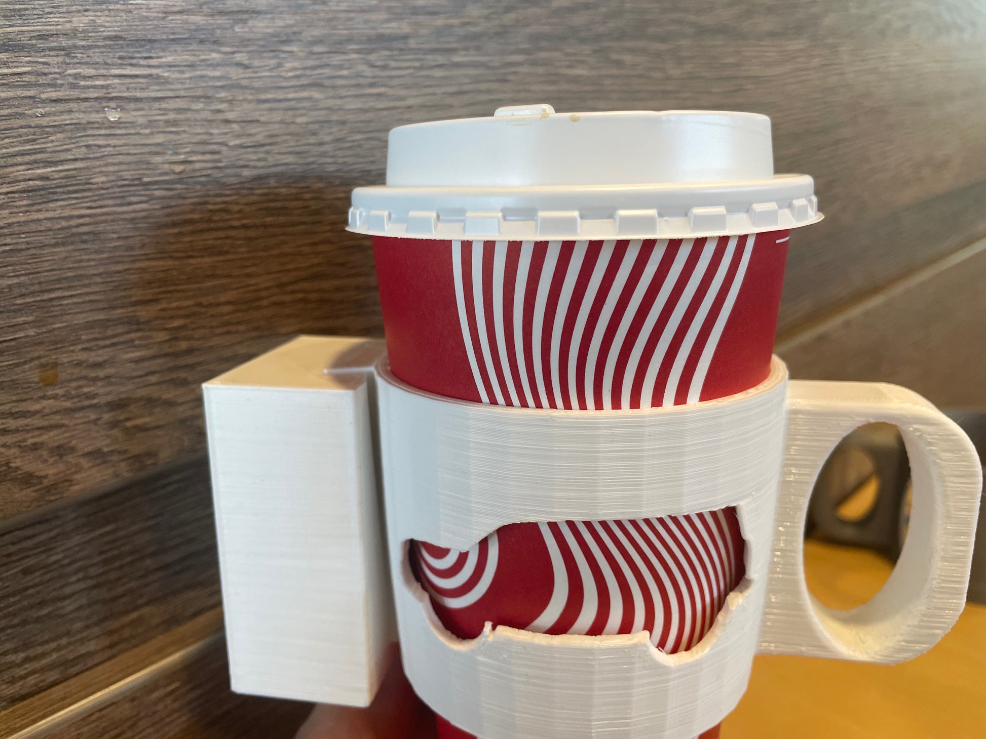 Red and white striped coffee cup with a white lid and 3D printed white cup holder.