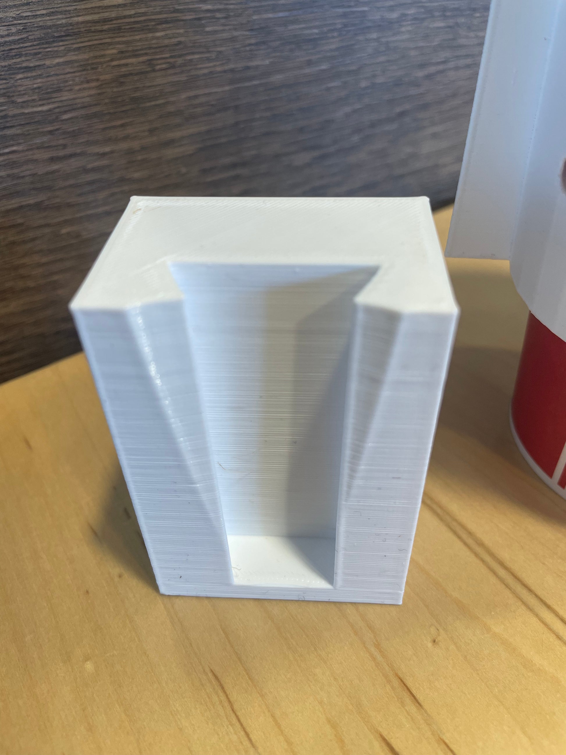 White 3D printed square planter pot with angled sides.