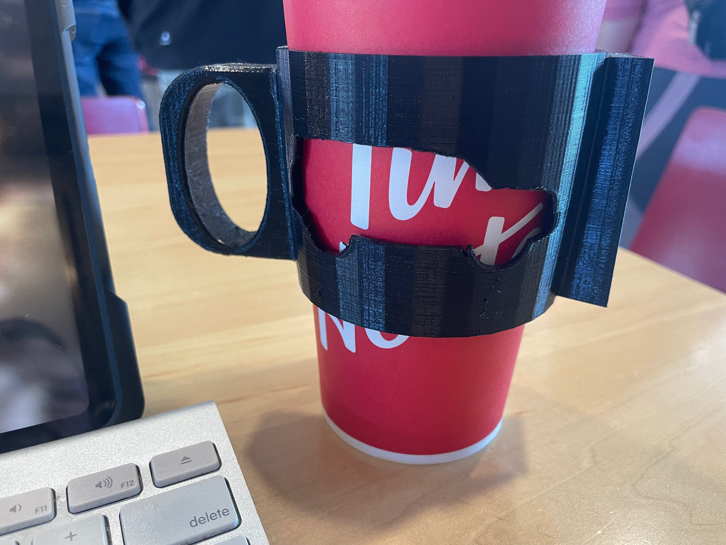 Red paper cup in a black 3D-printed handle.