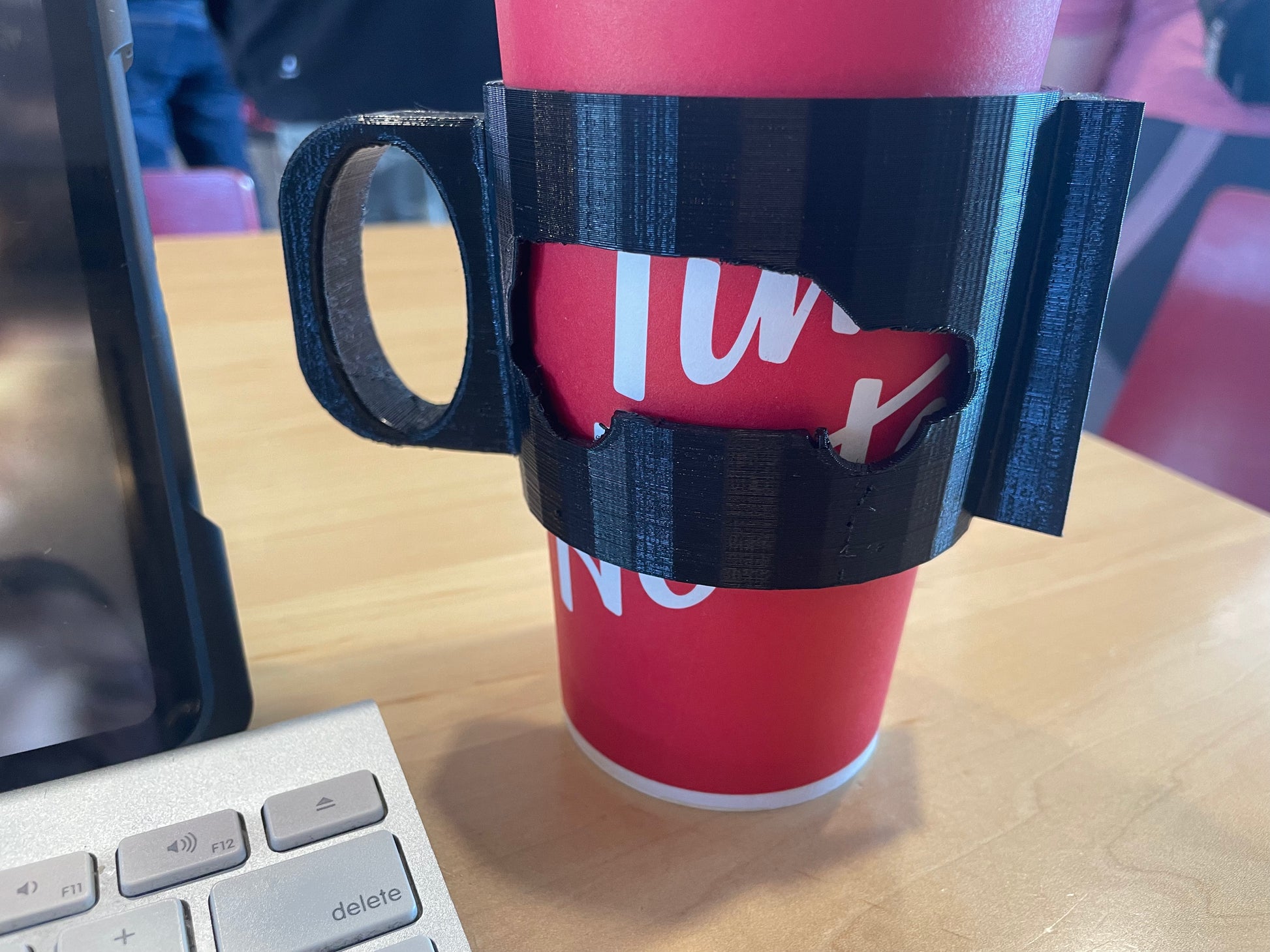 Red paper cup in a black 3D-printed handle.
